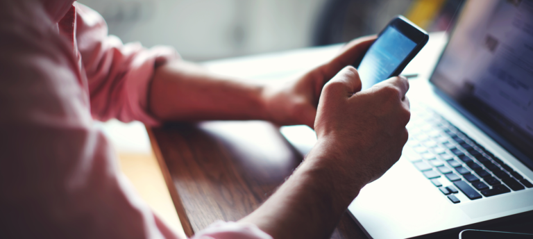 Student Holding Phone Accessing Telehealth